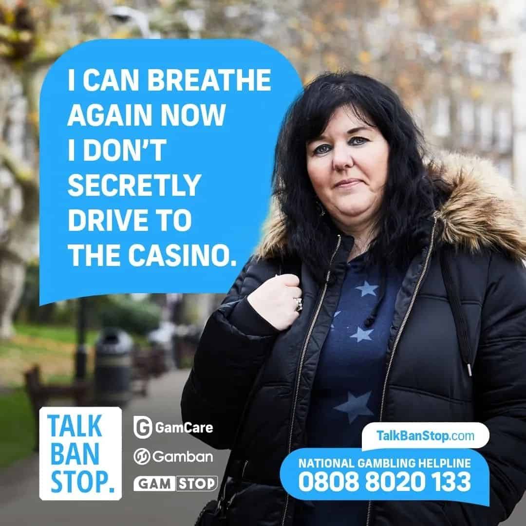 Woman holding a sign about overcoming gambling addiction, promoting Gamcare support.