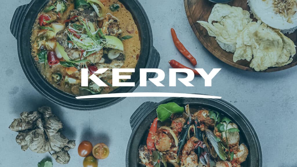 Malaysian seafood curry with vegetables served in a black bowl, garnished with herbs and chili.