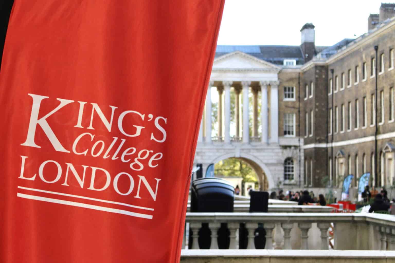 View of King's College London historic campus with classical architecture and university banners.